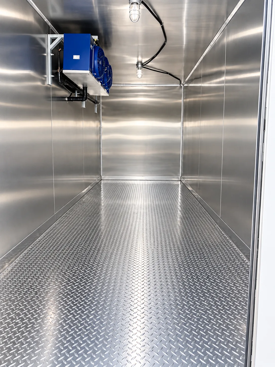 Empty stainless steel refrigeration trailer interior with overhead cooling unit
