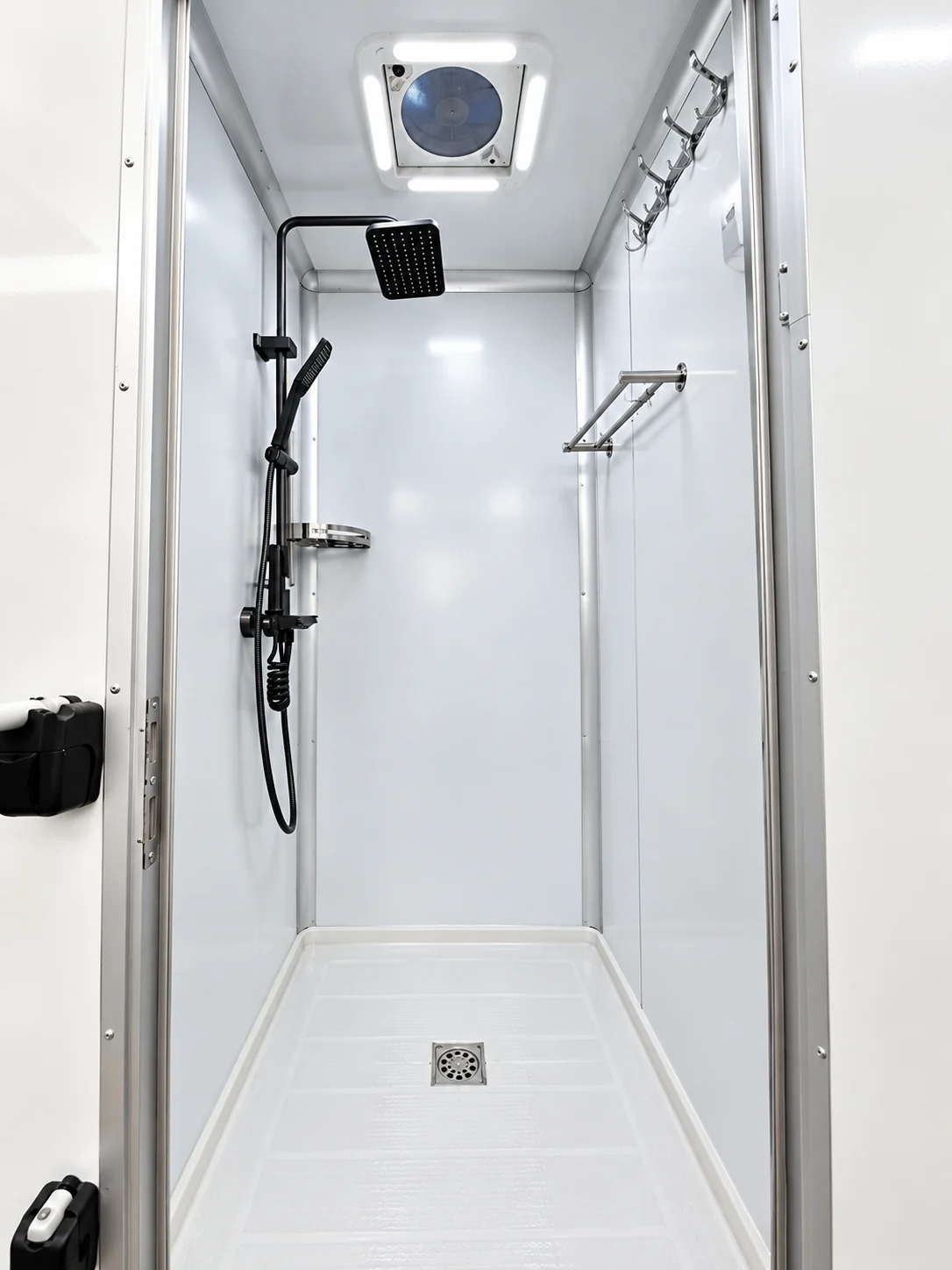 Shower cubicle with wall-mounted fittings and a handheld shower head